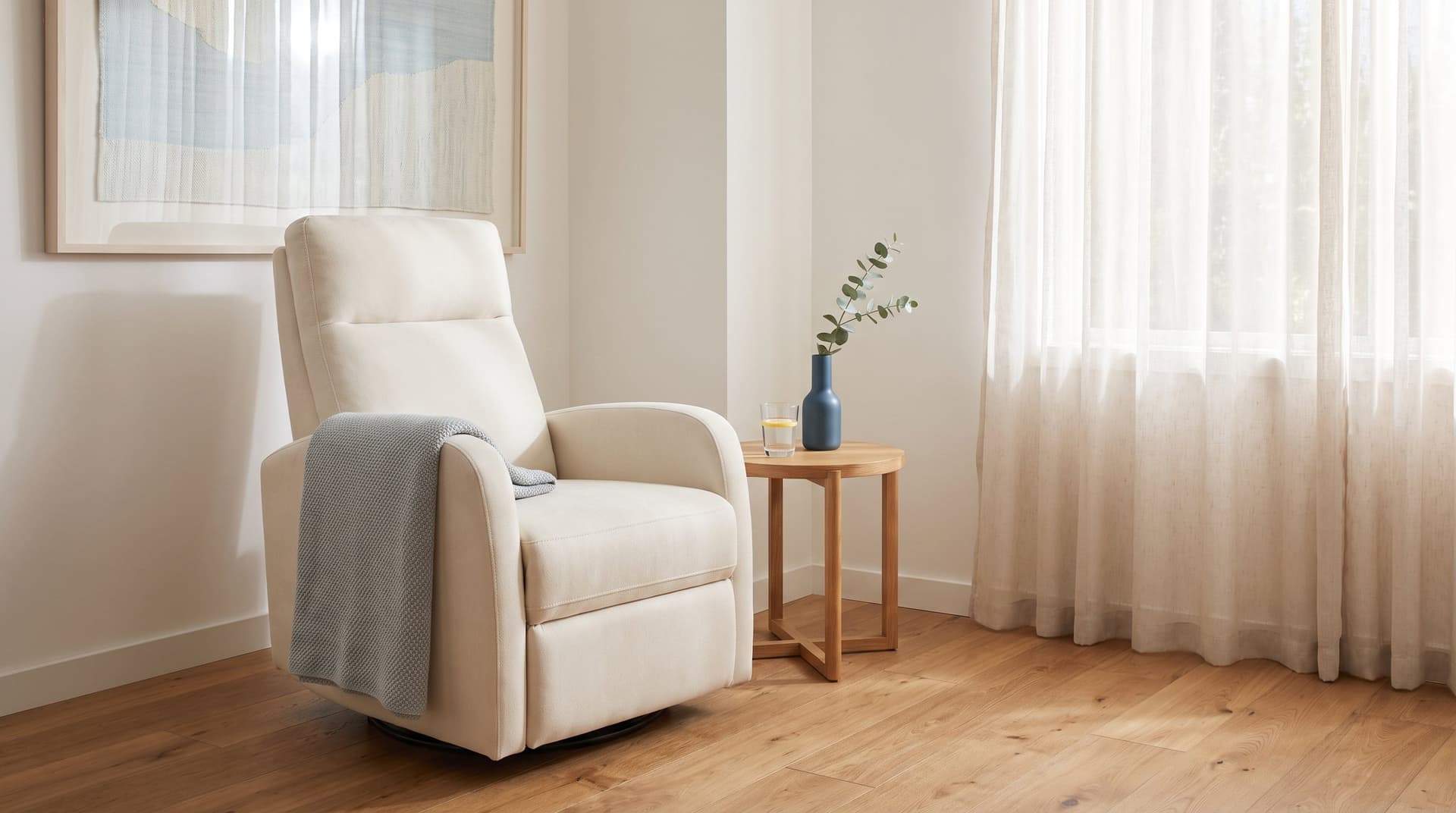 A quiet corner of a home with a cream recliner, folded throw and a small side table, prepared for a concierge treatment